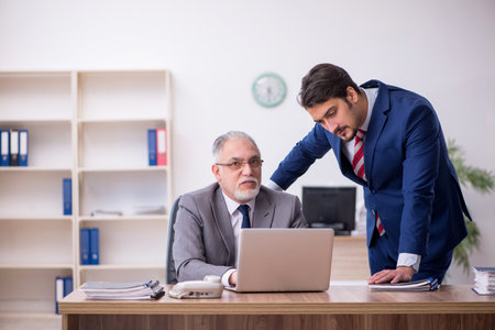 Two male employees working in the officeの写真素材