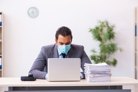Young male employee wearing mask during pandemicの写真素材