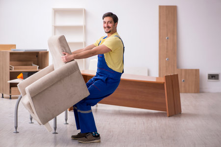 Young male carpenter repairing arm-chair in the officeの写真素材