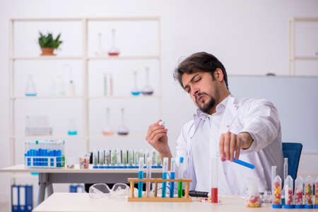 Young male chemist in drugs synthesis conceptの写真素材