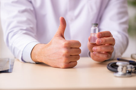 Young male doctor in vaccination conceptの写真素材
