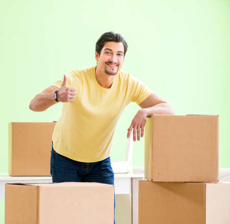Young handsome man moving in to new house with boxesの写真素材