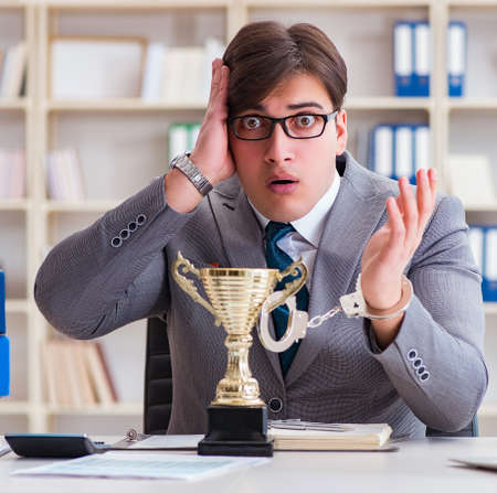 Businessman with golden cup in the officeの写真素材