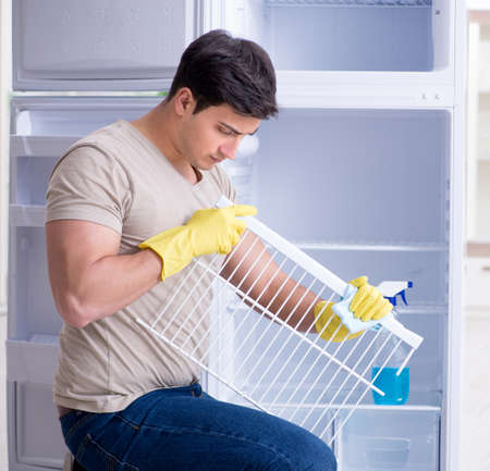 Man cleaning fridge in hygiene conceptの写真素材