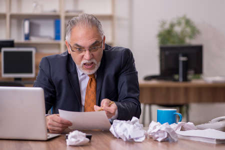 Old male employee in paper recycling concept