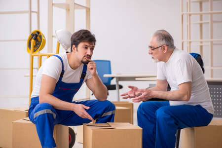 Two male professional movers doing home relocation