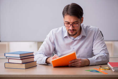 Young male teacher in front of whiteboardの写真素材
