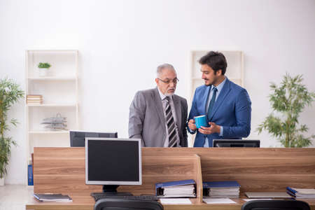 Two male employees working in the officeの写真素材
