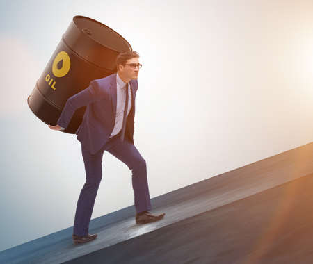 Businessman under the burden of oil barrelの写真素材