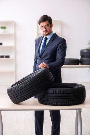 Young man selling tires in the officeの写真素材
