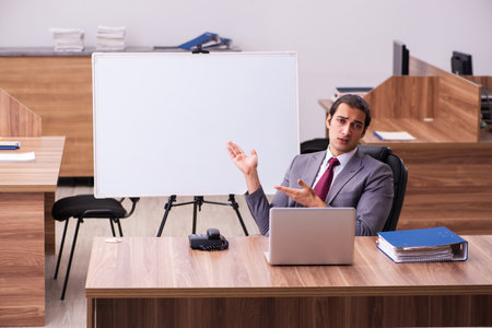 Young male business trainer in the office during pandemicの写真素材