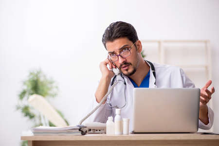 Young male doctor in telemedicine conceptの写真素材