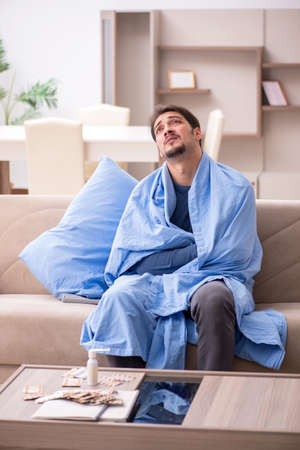 Young man feeling bad at homeの写真素材