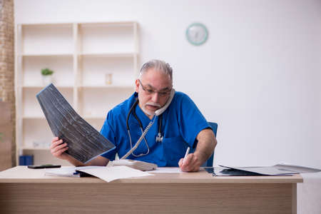 Old male doctor radiologist working in the clinicの写真素材