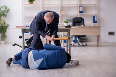 Old boss and young male employee in bullying conceptの写真素材