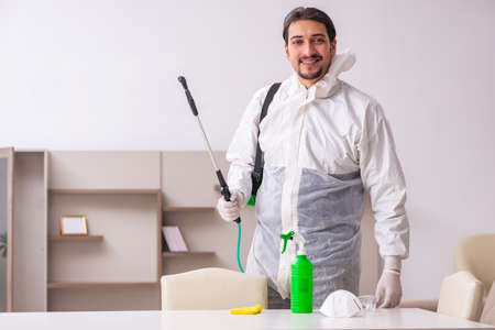 Young male contractor doing pest control at homeの写真素材