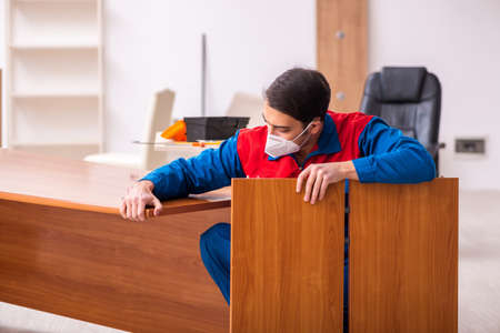 Young male carpenter working in the office during pandemicの写真素材