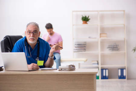 Young male patient visiting old male doctorの写真素材