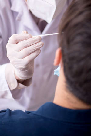 Young male patient visiting old male doctor during pandemicの写真素材