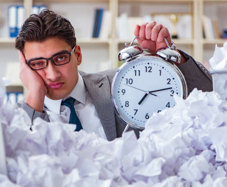 Businessman in paper recycling concept in officeの写真素材