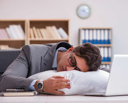 Tired man sleeping at home having too much workの写真素材