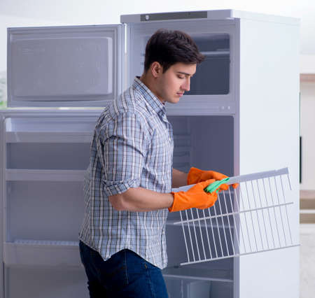 Man cleaning fridge in hygiene conceptの写真素材