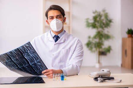 Young male doctor radiologist working in the clinic during pande