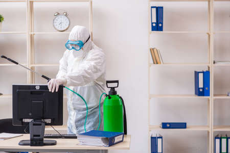 Old male contractor in office disinfection conceptの写真素材