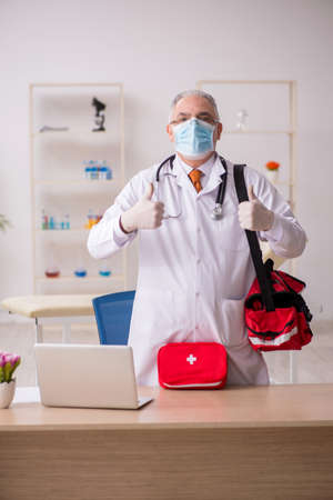 Old male doctor in first aid conceptの写真素材