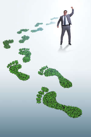 Ecology concept with green footprint and businessmanの写真素材