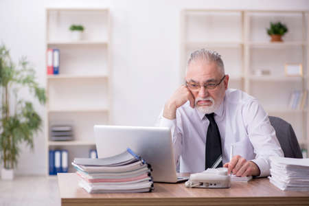 Old male employee working in the officeの写真素材