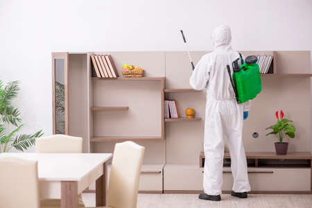 Young male contractor disinfecting at homeの写真素材