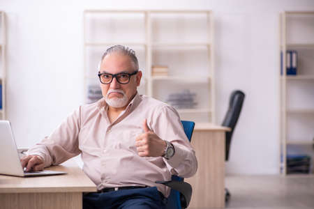 Old male employee working at workplaceの写真素材