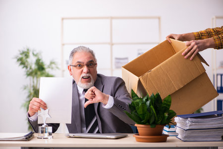 Old male employee in dismissal conceptの写真素材