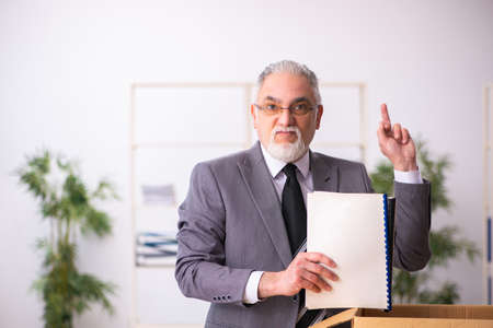 Old male employee in dismissal conceptの写真素材