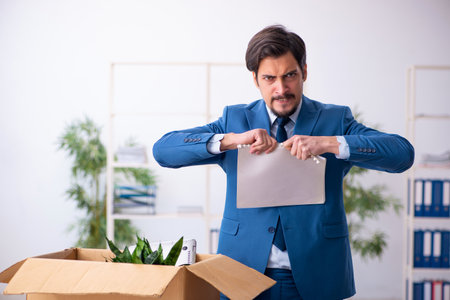 Young male employee in business relocation conceptの写真素材