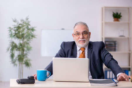 Old male employee working in the officeの写真素材