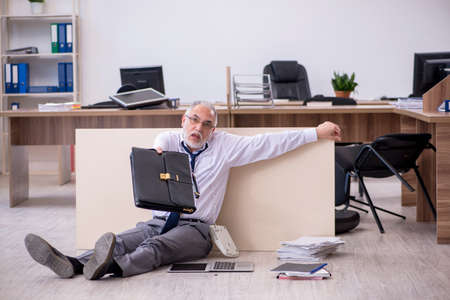 Old businessman employee in bankruptcy concept in the officeの写真素材