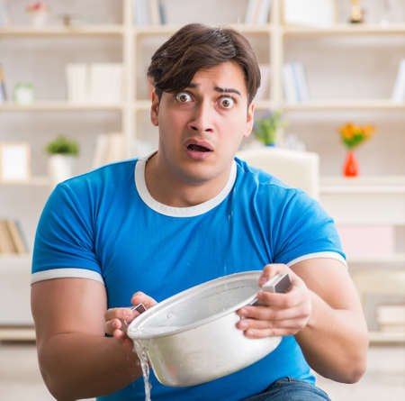 Man at home dealing with neighbor flood leakの写真素材