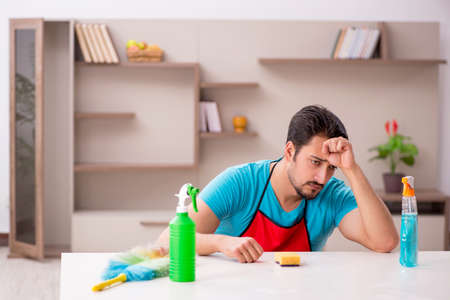 Young male contractor cleaning the house