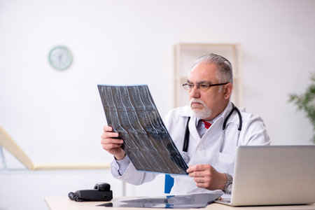 Old male doctor radiologist working in the clinic