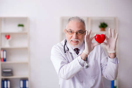 Old male doctor cardiologist working in the clinic