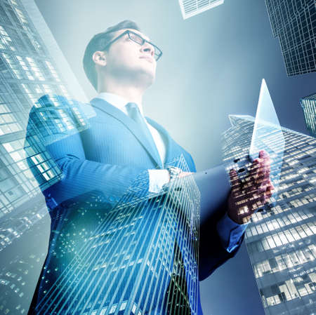 Businessman against buildings in business conceptの写真素材