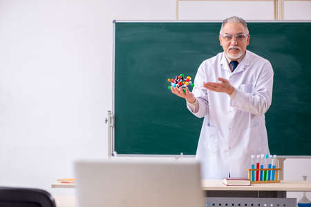 Old male teacher chemist in the classroomの写真素材