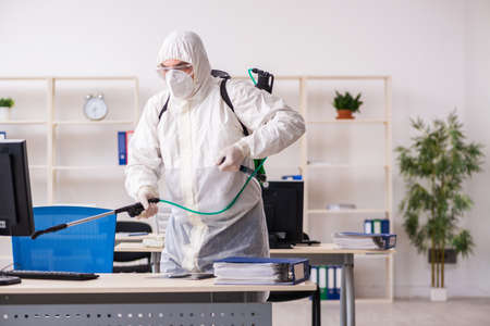 Old male contractor in office disinfection conceptの写真素材