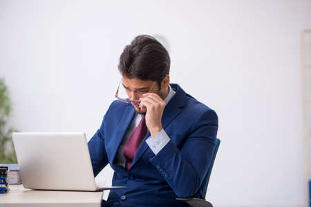 Young male employee working at workplaceの写真素材