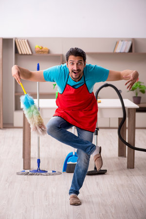 Young male contractor cleaning the houseの写真素材