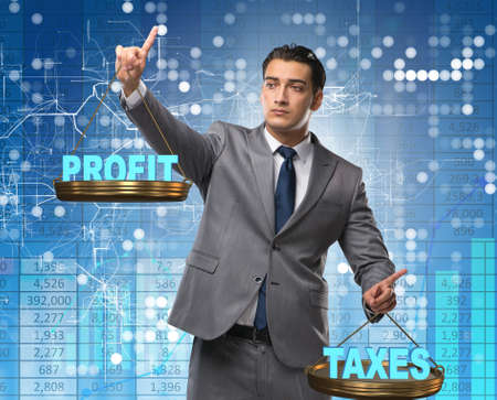 Businessman comparing profit and taxesの写真素材