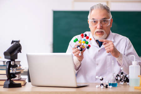 Old male teacher chemist in the classroomの写真素材