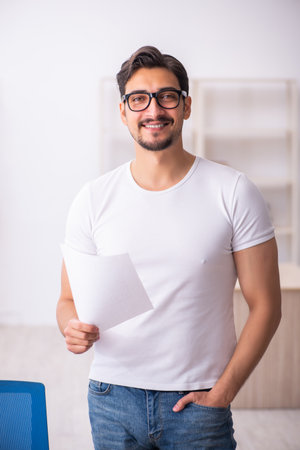 Young male student employee at workplaceの写真素材